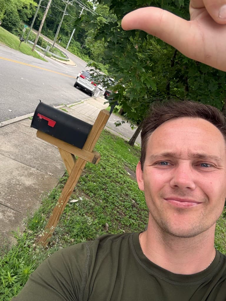 Mailbox Bros team member at a finished black post-mount mailbox install in Louisville